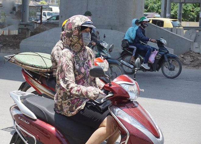 Hà Nội trải qua ngày nắng nóng gắt nhất từ đầu mùa, người dân bịt kín mít khi ra đường